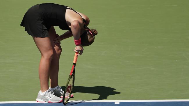 Jelena Ostapenko doubles over at the baseline during her gruelling three-set victory over Andrea Petkovic. Photo: AP