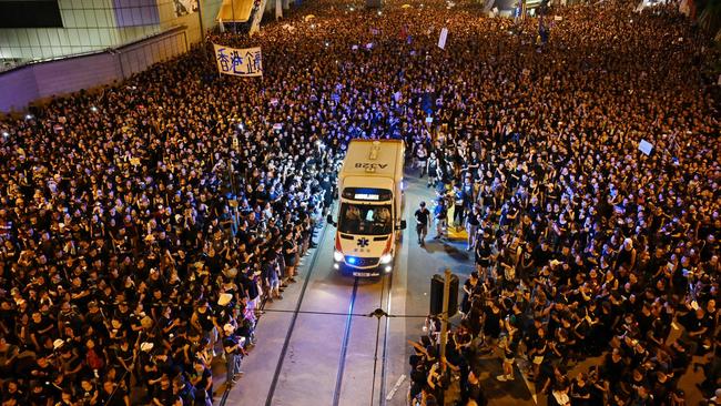 An ambulance is pictured surrounded by thousands of protesters dressed in black during a rally against the extradition law proposal.