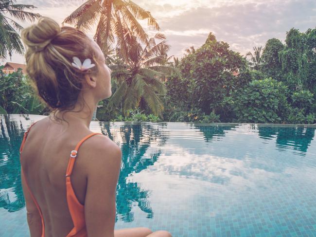 Young woman standing on the edge of an infinity pool, Ubud, Bali People travel vacations concept.Photo: iStockESCAPE20 February 2022News Column Bali