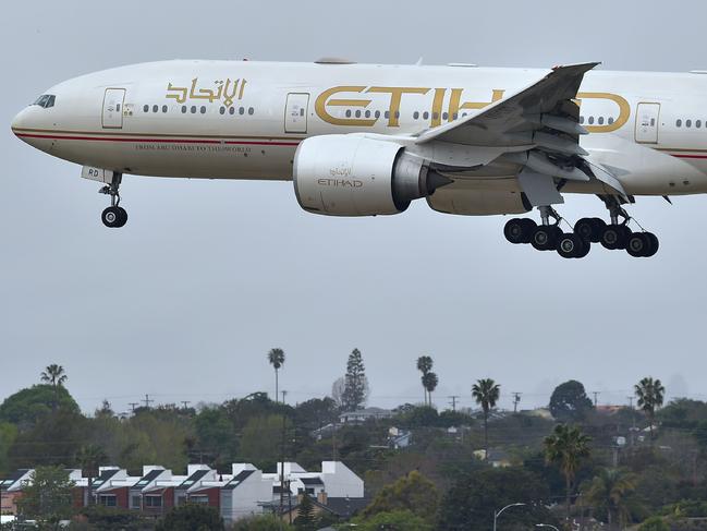 (FILES) This file photo taken on March 21, 2017 shows an Etihad Airways aircraft coming in for a landing at Los Angeles International Airport in Los Angeles, California.  Abu Dhabi's Etihad Airways said on June 5, 2017, it would suspend flights to Qatar after the United Arab Emirates was among major Gulf states to sever ties with Doha in an unprecedented regional crisis. / AFP PHOTO / FREDERIC J. BROWN