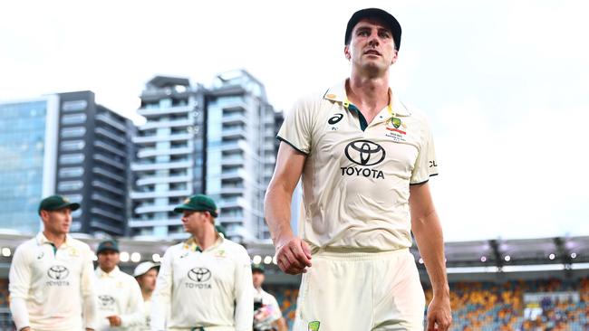 Pat Cummins leads his Australian team off the field at the end of day four at the Gabba after failing to enforce the follow on.