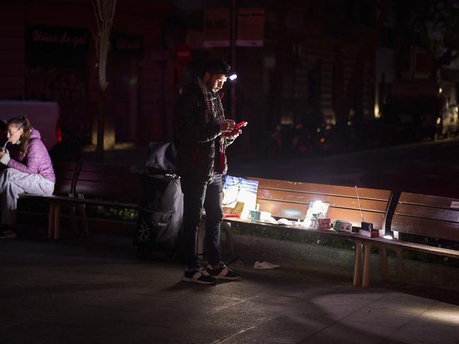 A man sells battery-powered radios and torches on a Barcelona street during the blackout in Barcelona, Spain, Tuesday, April 29, 2025. (AP Photo/Emilio Morenatti)