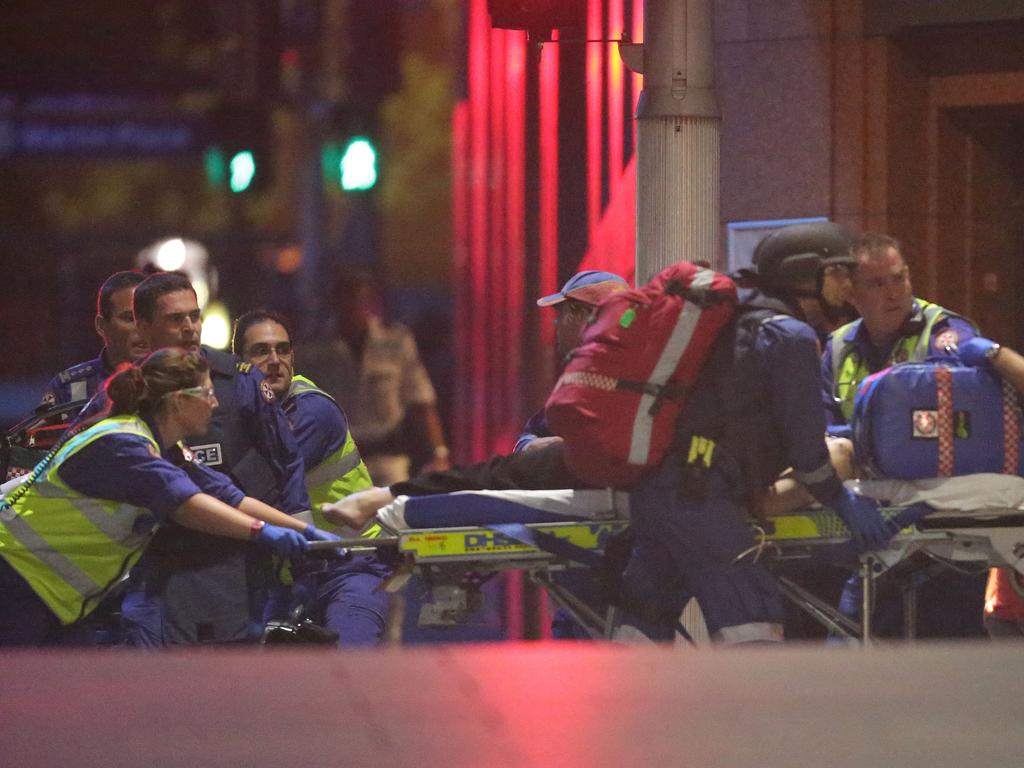 Ambulance crews rush in to treat the victims of the Sydney siege. Picture: Bill Hearne