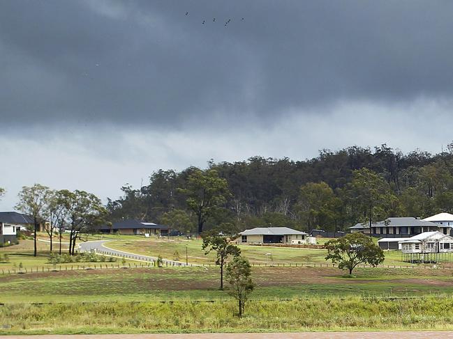 Storm Clouds hover above the homes at Grantham in the new estate, while the lower farming region is flooded. Ex Cyclone Oswald continues to wreak havoc across South- East Queensland.All roads going in and out of the Lockyer Valley is closed off. Pictures: Jack Tran / The Australian