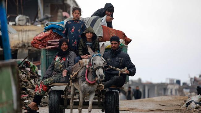 TOPSHOT - Palestinians use a donkey-pulled cart to transport their belongings as they flee Beit Lahia in the northern Gaza Strip on March 21, 2025. Gaza's civil defence agency said on March 20 that 504 people had been killed since the bombardment resumed, more than 190 of them minors. (Photo by Bashar TALEB / AFP)