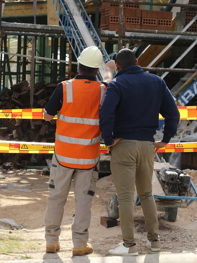 A SafeWork inspector speaks to a builder outside the construction site. Picture: Tim Hunter