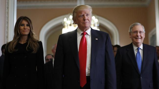 The man with his finger on the button. President-elect Donald Trump and his wife Melania walk with Senate Majority Leader Mitch McConnell. Picture: Alex Brandon