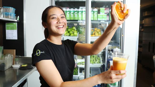 Orange juice is often ditched for low-sugar and green juice options at O Superfood in Sydney’s Bondi Junction. Staff member Meeya Kajangvath, pictured, squeezes an orange to make a drink. Picture: John Feder