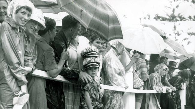 Gold Coast Crowds wait for Queen Elizabeth II in rain at Coolangatta Surf Club.