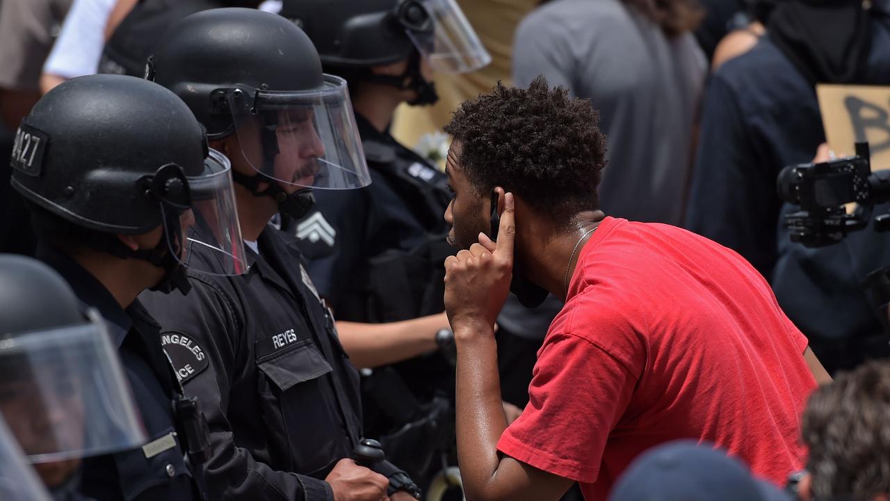 A man cups his ear to listen to an LAPD officer during protests sparked by the death of George Floyd. Picture: Agustin Paullier / AFP