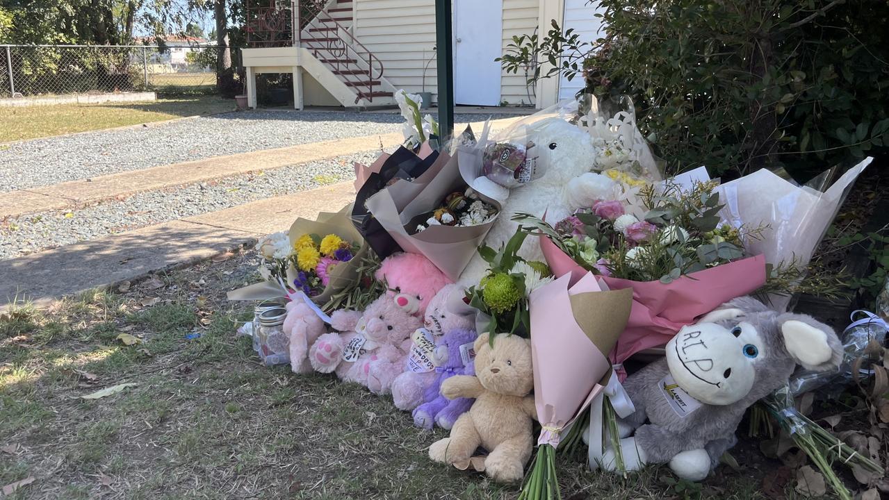 Tributes of flowers and toys sit at the mailbox of the Bean St in Rockhampton home where Tayla and baby Murphy lived.