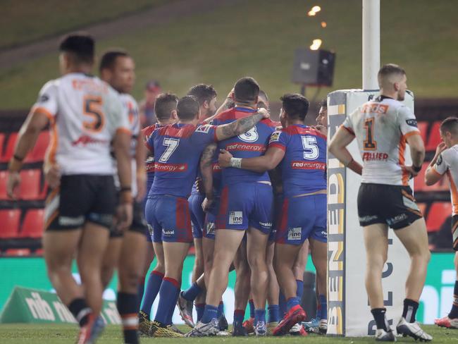 The Tigers players look on as the Knights celebrate a try.