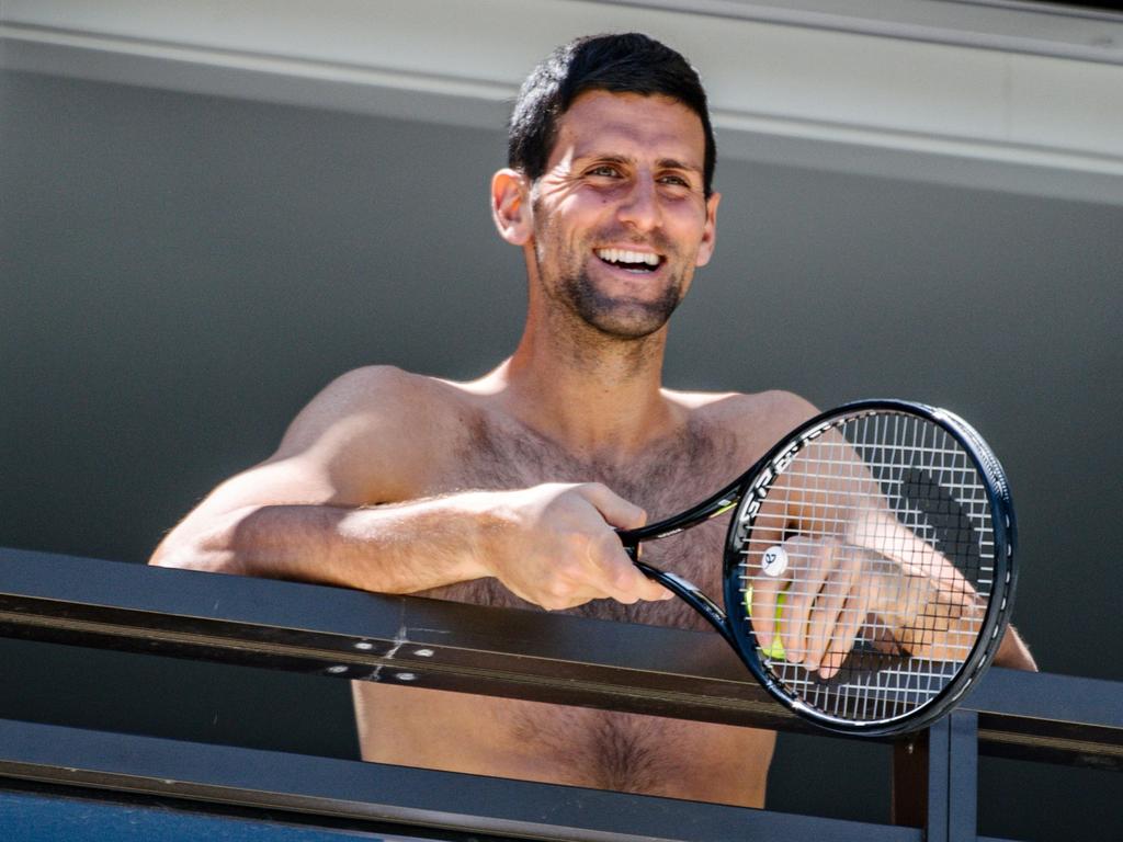 Men's world number one tennis player Novak Djokovic responds to fans from a hotel balcony in Adelaide, one of the locations where players have quarantined for two weeks upon their arrival ahead of the Australian Open. (Photo by Morgan SETTE / AFP)