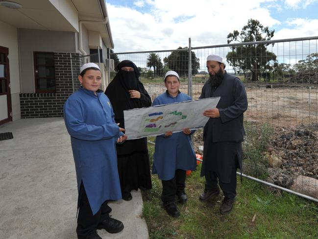 Rahat and Fazeel Arain look at plans for Al Siraat College with students.