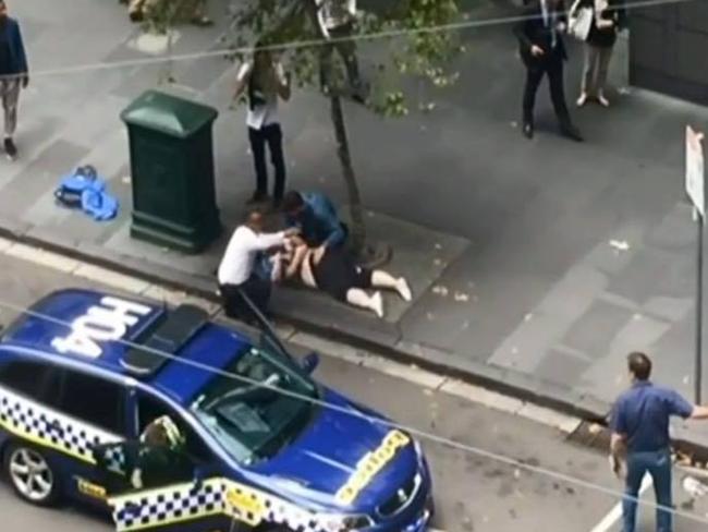 Young Melbourne man Henry Dow helps a victim with a taxi driver during the Bourke Street tragedy. Picture: Channel 7