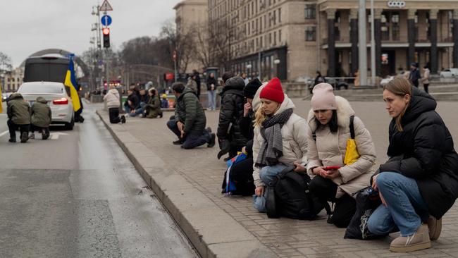 People kneel to honour a fallen Ukranian soldier during a funeral procession at the Independence Square in Kyiv, on January 3. Picture: Tetiana Dzhafarova/AFP