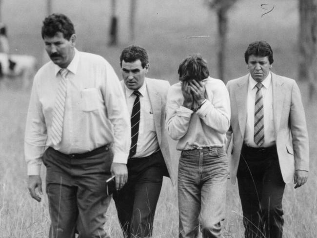 Head in hands, Mick Murphy accompanies detectives led by Ian ‘Speed’ Kennedy through the paddock at Reen Road, Prospect where he raped and murdered Anita Cobby.