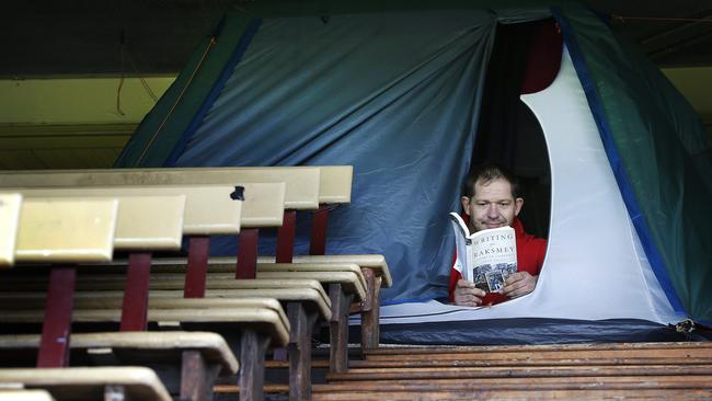 Homeless man Mitch Turner pictured reading a book in his tent last year. Picture: David Caird