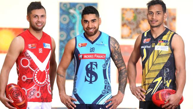 Robert Young (left), Byron Sumner and Marlon Motlop have designed the Indigenous jumper for their teams. Picture: Dean Martin