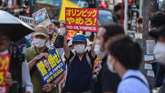 A man holds a placard during a protest against the hosting of the Tokyo 2020 Olympic Games in Tokyo on July 23, 2021. (Photo by Philip FONG / AFP)