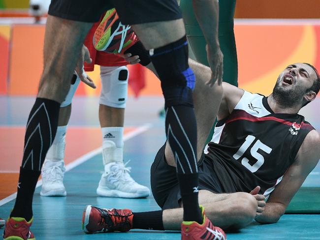Egypt’s Ahmed El Kotb reacts in pain after injuring himself during the men’s qualifying volleyball match between Poland and Egypt