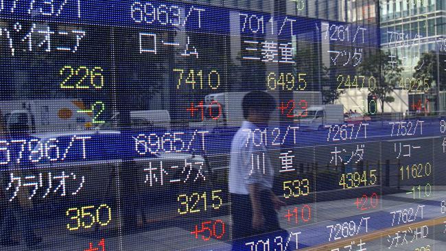 Global stocks and Asian currencies fell yesterday after China unexpectedly devalued its yuan in response to weakening trade and growth. (AP Photo/Ken Aragaki)