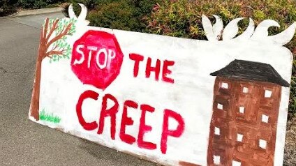 Some of the signage at the Ecovillage at Currumbin on the Gold Coast where residents oppose a development application for shops.