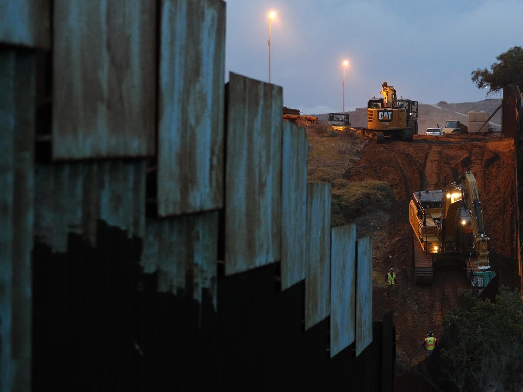 Contractors work to reinforce a section of the US border wall in San Diego where scores of Central American migrants have crossed illegally in recent weeks. Picture: AP