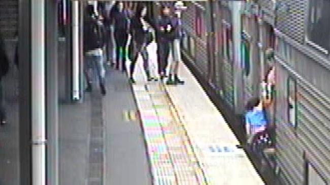 A woman is about to lose her grip on a young child at Epping Station last October. Picture: Sydney Trains