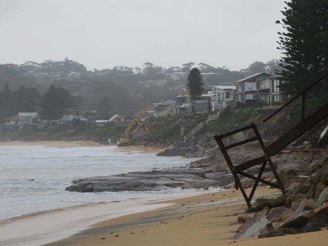 An excavator and workers on site at Wamberal on Tuesday morning, July 28, where emergency works to prevent further erosion appear to be working. Picture: Richard Noone