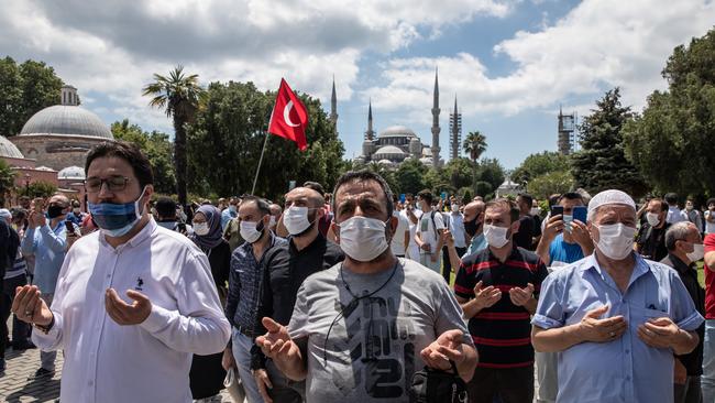 The Blue mosque is seen in the background as people pray facing Istanbul’s famous Hagia Sophia during Friday prayers in Istanbul, Turkey. Picture: Getty Images