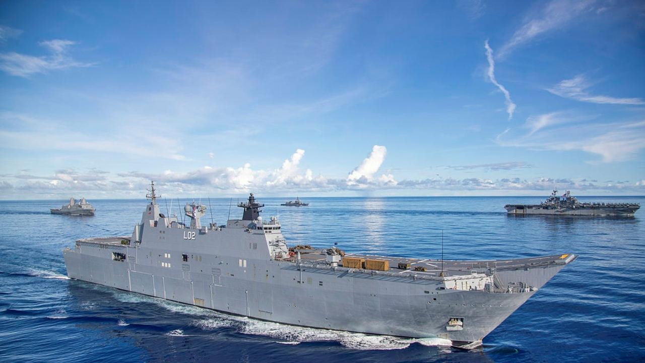 HMAS Canberra (front) conducts maritime manoeuvres .