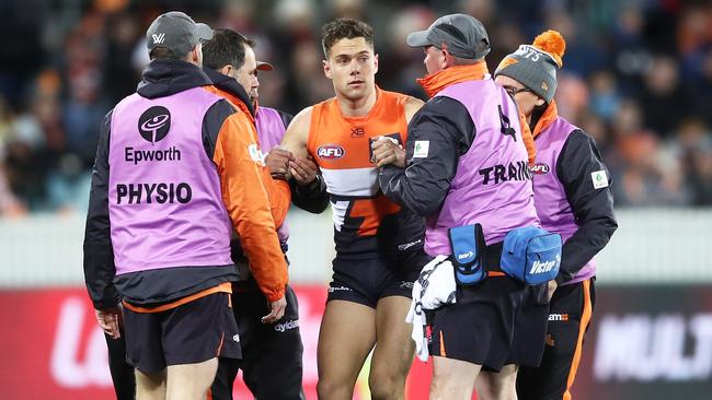 Josh Kelly of the Giants is assisted after a sling tackle from Taylor Walker.