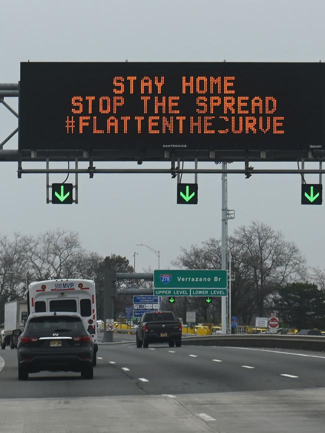 Cars drive under an electronic sign board warning drivers about coronavirus in New York. Picture: AFP.