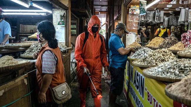 A cleaner disinfects at a traditional market to curb the spread of COVID-19 in Yogyakarta, Indonesia. The Indonesian government will gradually open shopping malls, restaurants and entertainment sites from June in an attempt to open the economy despite a continuing rise in cases.