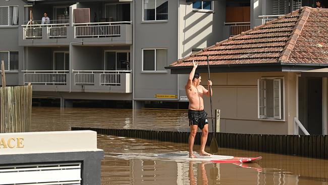 Students paddle around their flooded apartment blocks in St Lucia , after floods and rain swamped Brisbane. Pic Lyndon Mechielsen/The Australian