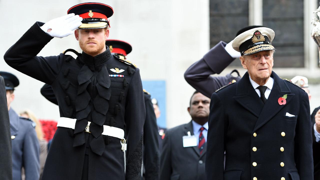 Britain’s Prince Harry, left, salutes as he stands alongside his grandfather Prince Philip, Duke of Edinburgh, during their visit to the Field of Remembrance at Westminster Abbey in central London on November 10, 2016. Picture: AFP