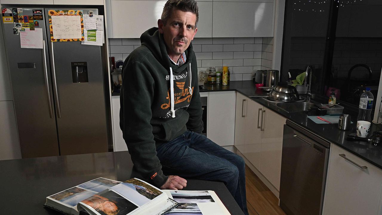 Lee Lovell with family photo books in the kitchen of his North Lakes home. Picture: Lyndon Mechielsen/Courier Mail