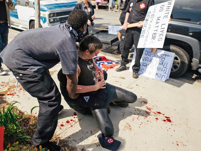 Two counter-protesters scuffling with a KKK member in Anaheim on Saturday. Picture: Eric Hood/OC Weekly via AP