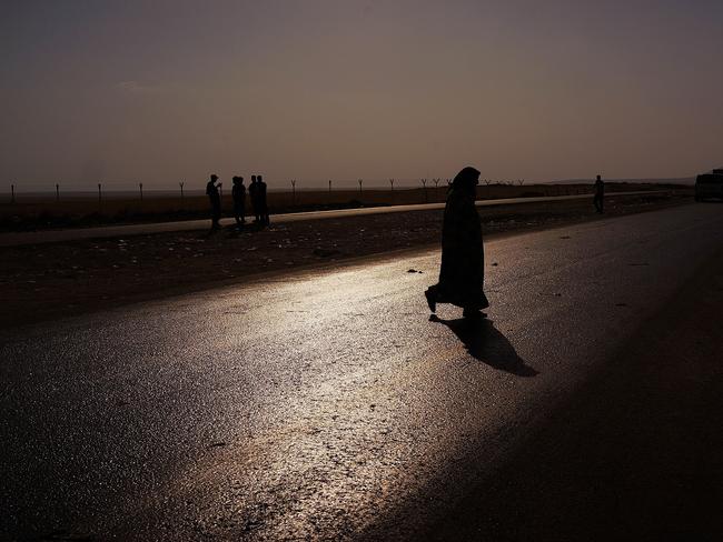 Dawn of a new empire? An Iraqi woman crosses a road near a displacement camp for those caught-up in the fighting in and around the city of Mosul.