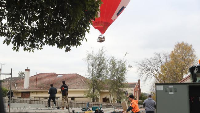 Builders watch on as the balloon drifts towards Faircroft Ave Glen Iris. Picture: Alex Coppel