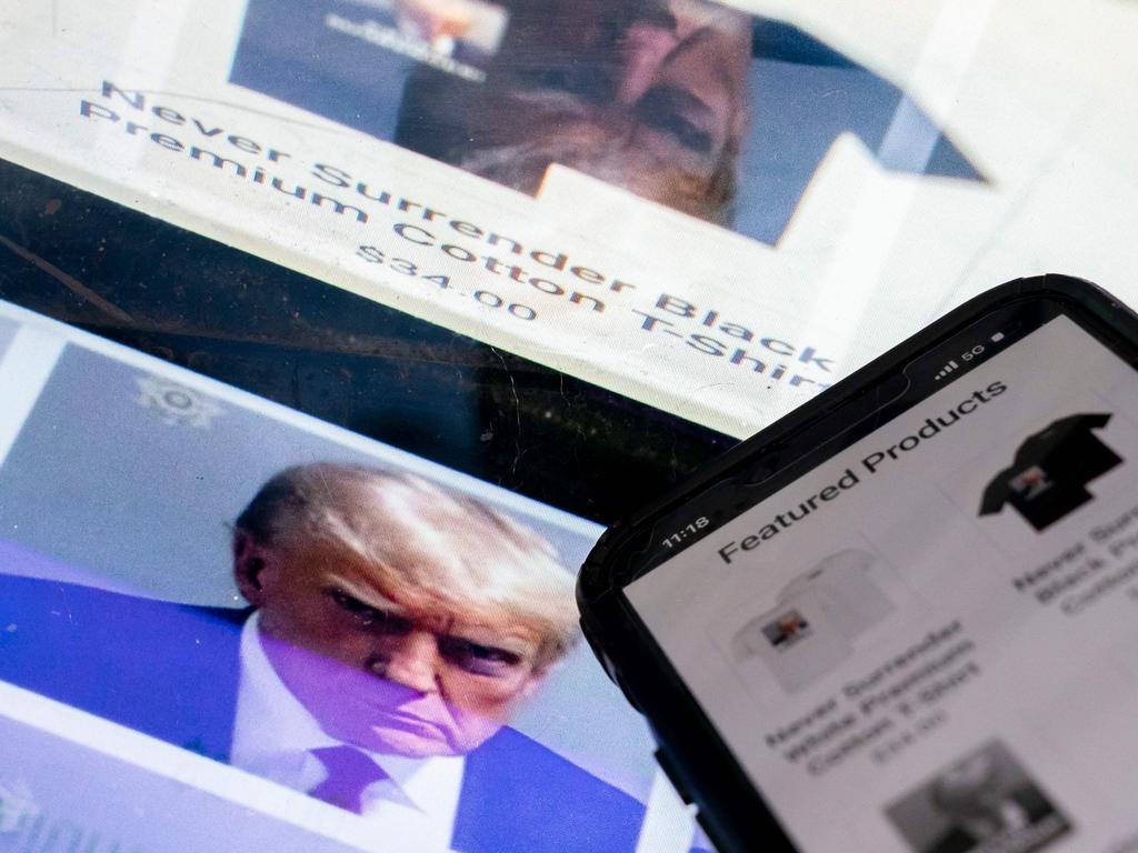 (ILLUSTRATION) This photo illustration created in Washington, DC, on August 27, 2023, shows the mugshot of former US President Donald Trump next to a website called Trump Save America JFC, a joint fundraising committee on behalf of Donald J. Trump for President 2024, which is selling merchandise bearing his mugshot. For most people, a police mug shot would be a badge of dishonor they would do anything to erase. For Donald Trump, it's a branding opportunity and political weapon. The scowling, vengeful stare captured at a Georgia jail on August 24, 2023, after Trump was booked on racketeering and conspiracy charges has quickly become his 2024 campaign symbol. T-shirts, mugs, stickers and beverage coolers bearing the first mug shot of a serving or former US president were put out by his team within hours of the photo's release. (Photo by Stefani Reynolds / AFP)