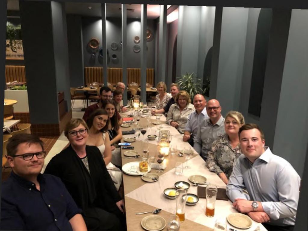 An image shows Brittany Higgins (third from left) seated next to Linda Reynolds at a staff dinner.