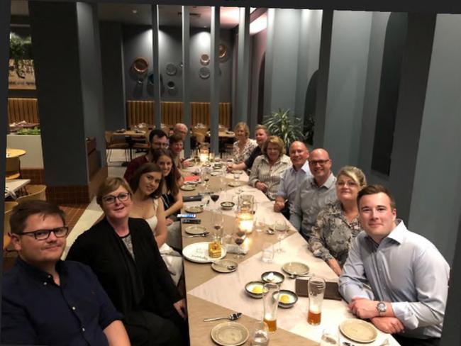 An image shows Brittany Higgins (third from left) seated next to Linda Reynolds at a staff dinner.