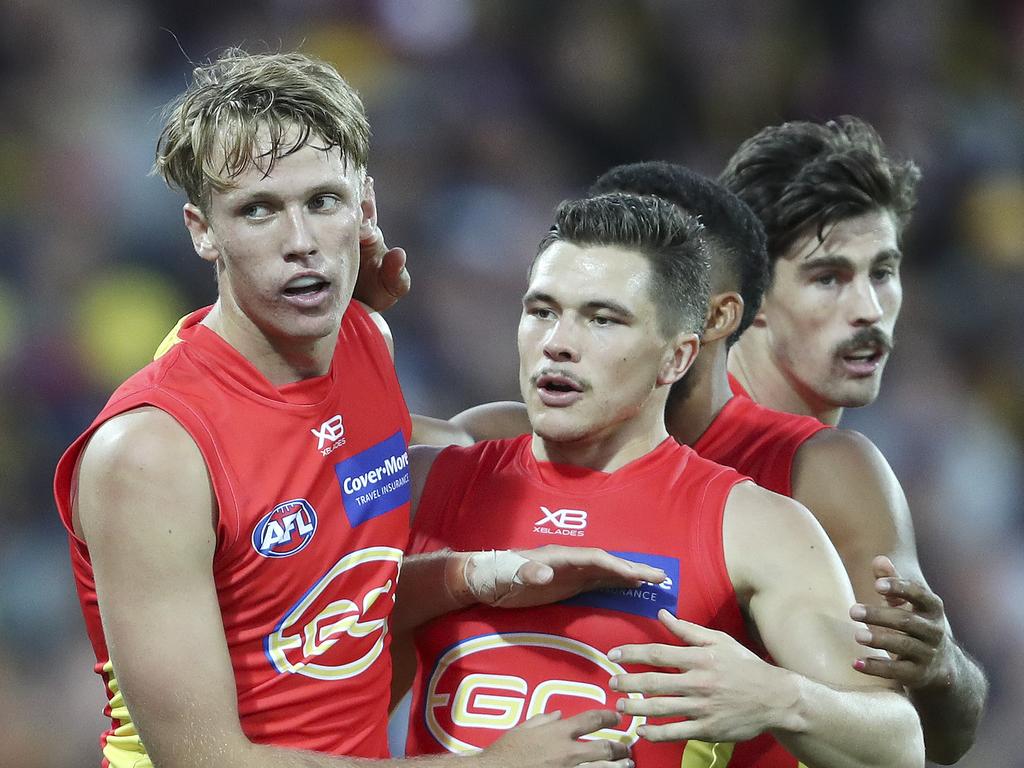 Jack Lukosius celebrated with teammates after his first AFL goal.