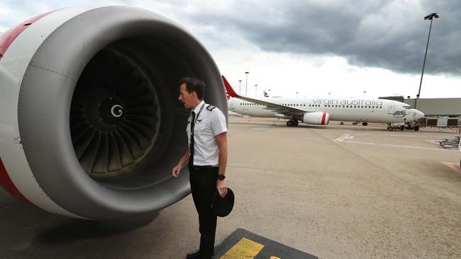 Virgin First Officer Ian Morrison performs a pre-flight inspection on his aircraft at Brisbane Airport before taking off on a flight to Sydney. Picture: Lyndon Mechielsen