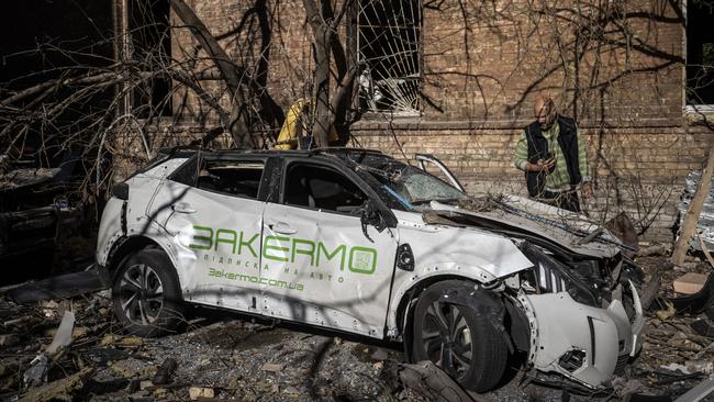 A man examines a destroyed car destroyed by a missile strike in a residential area near Tower 101, not far from Kyiv's main train station. Picture: Getty Images