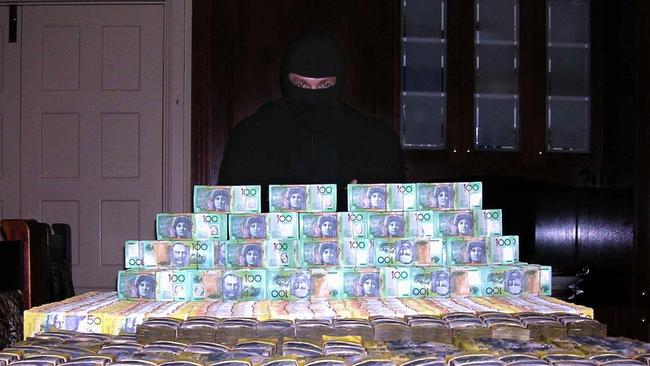 A man in a balaclava said to be surfer Shayne Hatfield poses with a huge pile of cash in a 2005 copy photo. The photo was found when police from Operation Mocha raided his house and arrested him. Hatfield was allegedly part of a cocaine trafficking syndicate.