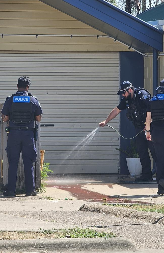 Police hose blood off the driveway of Annmarie’s Garbutt residence after she had her arm severed by her dog.