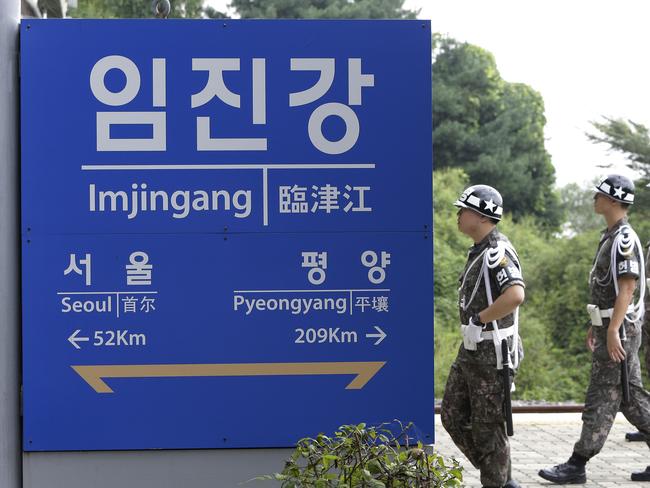South Korean army soldiers walk by a signboard showing the distance to the North Korean capital Pyongyang and to South's capital Seoul from Imjingang Station near the border village of the Panmunjom in Paju, on September 11, 2016. Picture: AP/ Ahn Young-joon